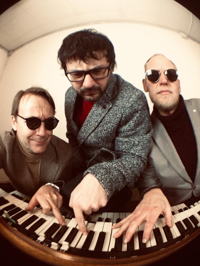 The Shu Shu's — fisheye promotional photo of the trio leaning over the keyboard
